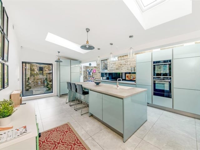 The well equipped kitchen has fitted units and appliances that include a five ring Neff induction ceramic hob with extractor hood, and a shoulder level oven, with Neff slide and hide ovens and warming drawer. A ceramic splashback has an integrated smart TV function. There's a pantry and a breakfast island, plus built-in fridge and dishwasher.