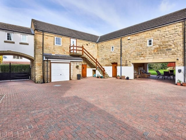The position of the underpass archway naturally creates a perfect space for an undercover outdoor dining area and the block paved drive continues through the passage to form a path around the property