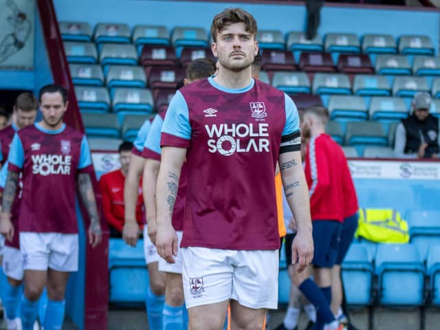 Skipper Alex Metcalfe leads the Em;ey team out fot the NCE League Cup final at Scunthorpe United's Glanford Park. Pictures: Mark Parsons