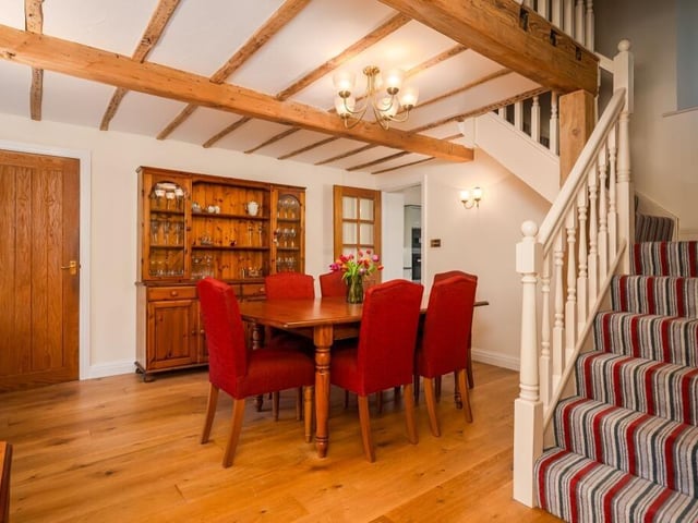 The beamed dining room, with staircase to a gallery landing.