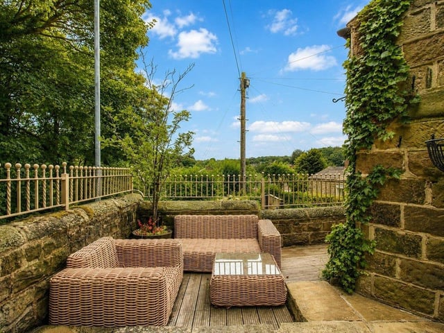 The garden is also complemented by mature shrubs and flowering plants and is enclosed by a combination of stone walling, iron railings and a timber gate.