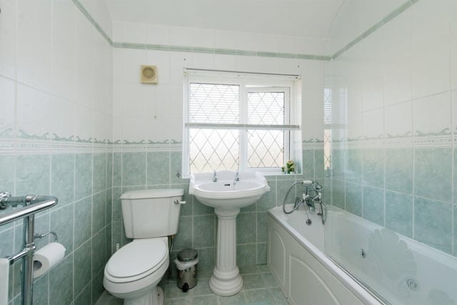 The tiled family bathroom includes a bath with shower over.