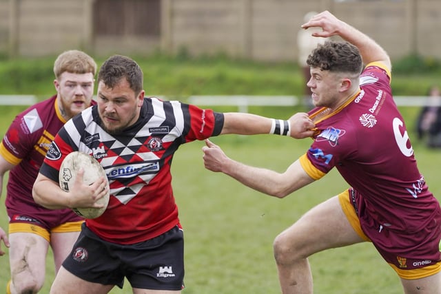 Normanton Knights full-back Connor Wilson holds off a would-be Wigan St Judes tackler.