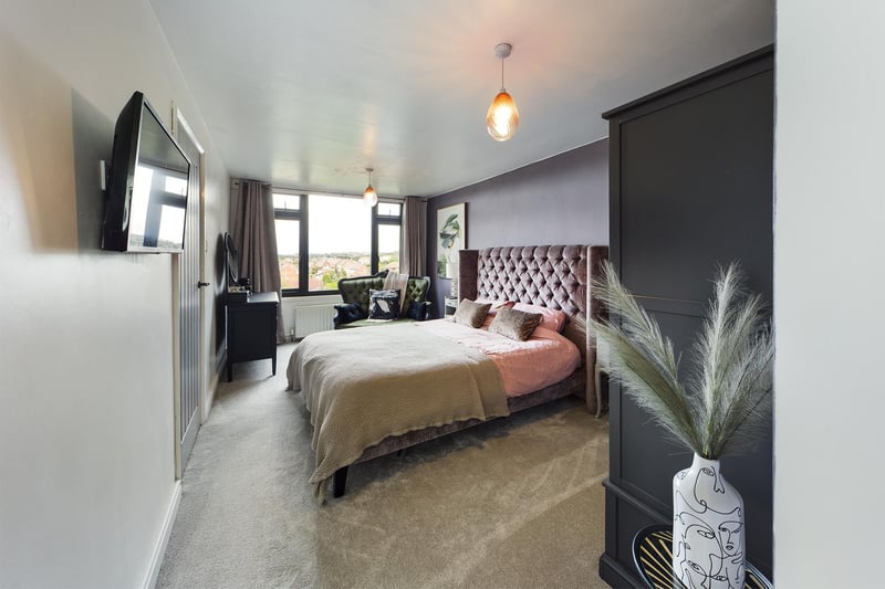 A stylish double bedroom with far reaching views through its window.