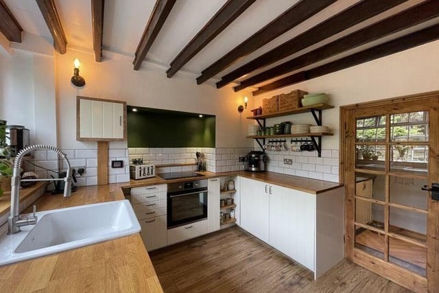 The beamed kitchen has underfloor heating, and fitted units with oak worktops.