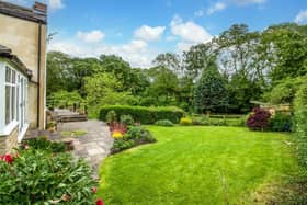 The property has extensive gardens with patio seating areas.