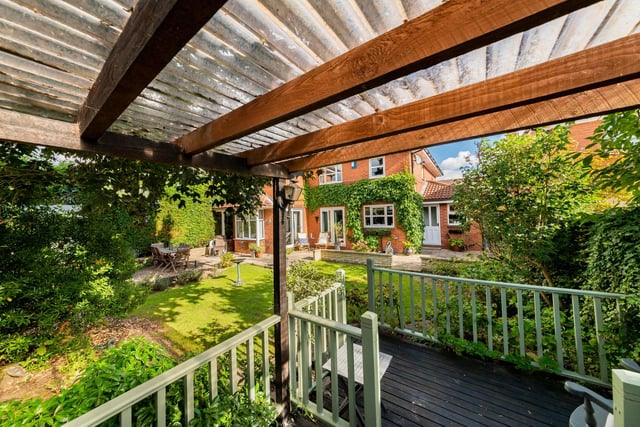 A decked and covered pergola has views back across the garden to the rear of the house.
