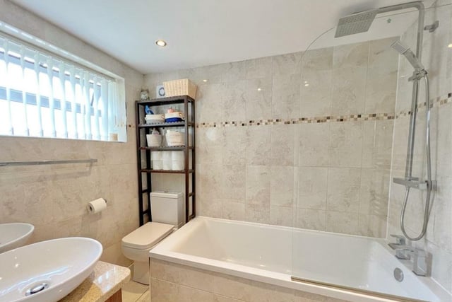 The family bathroom suite includes a large panelled bath with shower over, and twin washbasins with vanity unit beneath.