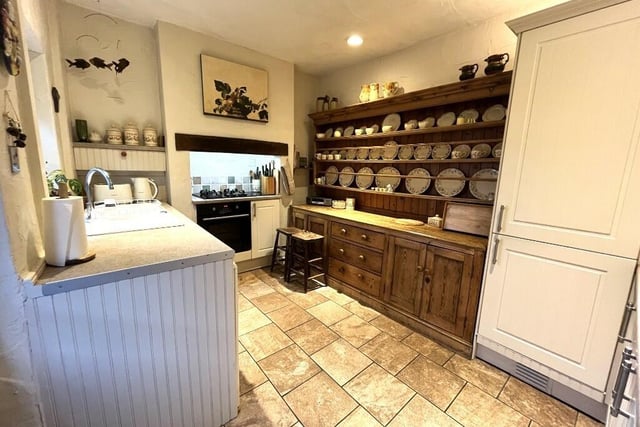 The country style kitchen has fitted units and integrated appliances.