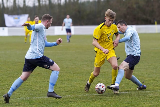 Nostell MW's Harvey Booth takes on two Beverley Town defenders.