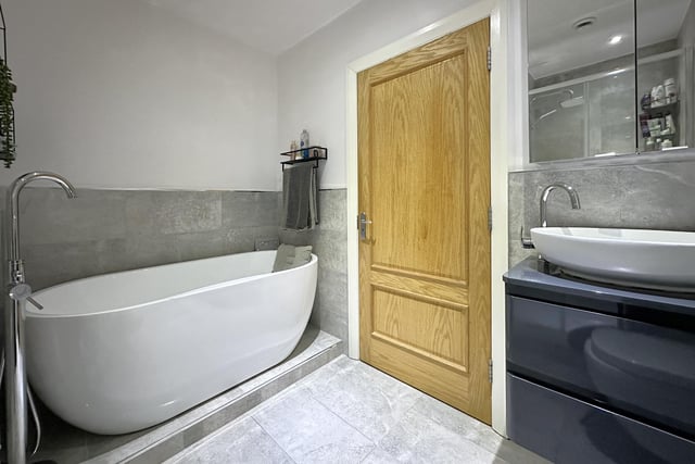 A section of one of the modern bathrooms, with free standing bath and walk-in shower.