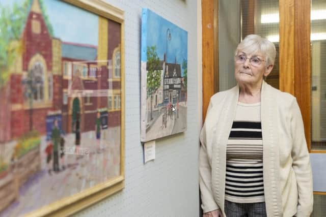 Alma Harrison with two of her paintings at Pontefract Art Club's exhibition at the town's library.