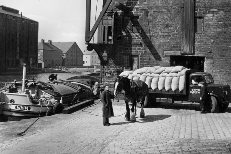 British Waterways Transport unloading cocoa beans for Rowntrees factory at Wakefield. A barge is moored on the quayside with a waiting cart horse. (Photo by John Tarlton/Fox Photos/Getty Images)