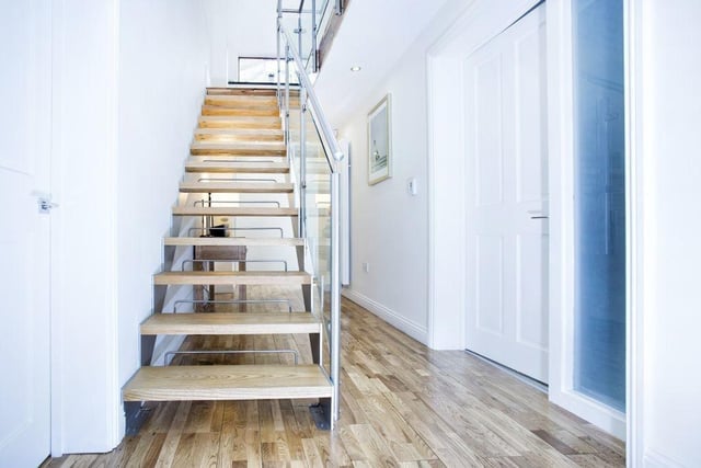 The staircase with glass balustrade links the floors of the property.