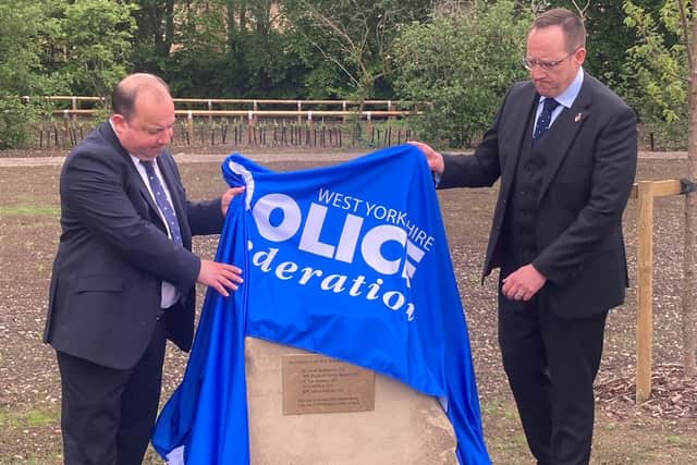 Matthew Morley, Wakefield Council's cabinet members for planning and highways, and Craig Nicholls, chair of West Yorkshire Police Federation, unveil the memorial to five police officers killed in a coach crash at Newton Hill roundabout.