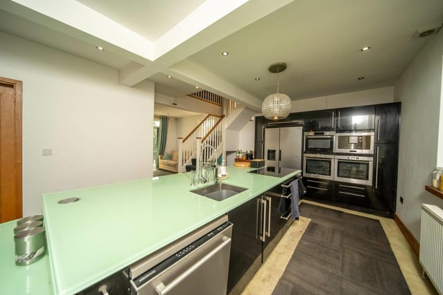 The bespoke kitchen has a central island with glass worktop.