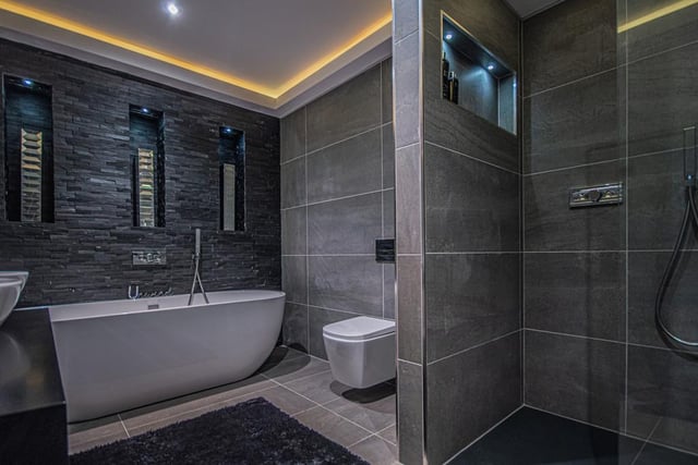 A free standing bath tub and walk-in shower unit feature within this deluxe bathroom.