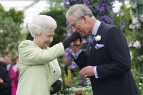 Queen Elizabeth II presents Prince Charles, Prince of Wales with the Royal Horticultural Society's Victoria Medal of Honour during a visit to the Chelsea Flower Show. (Pic credit: Sang Tan / WPA Pool / Getty Images)