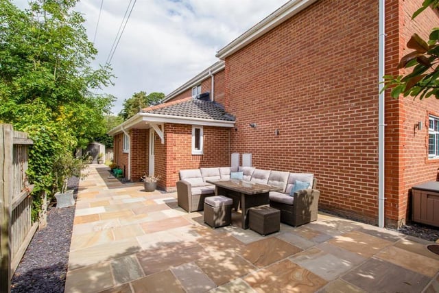 At the rear of the garage there is an Indian stone terrace patio with a stone path leading around the side of the house into the rear garden
