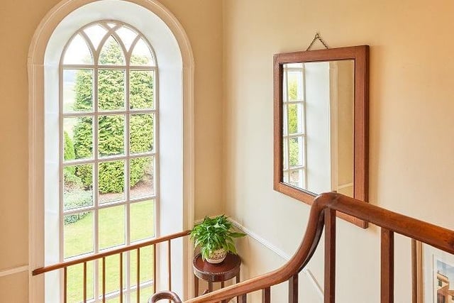 A large feature window on the turned staircase floods both hall and landing with natural light.