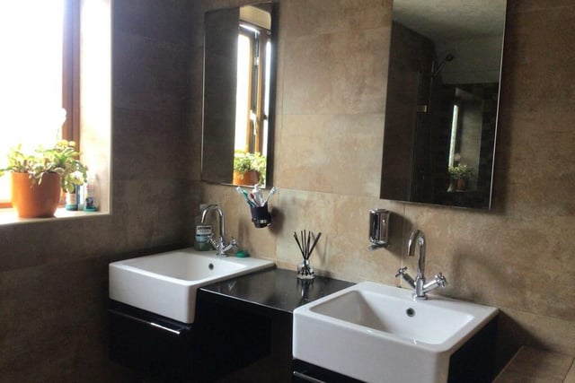 Twin wash basins feature in the bathroom.