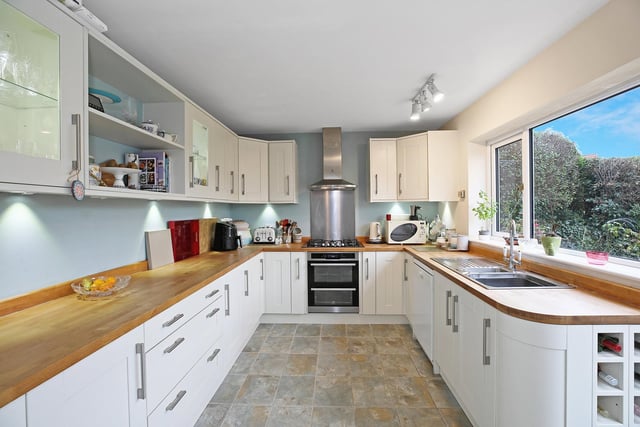 The fitted kitchen with shaker style units and solid oak worktops has a useful pantry.