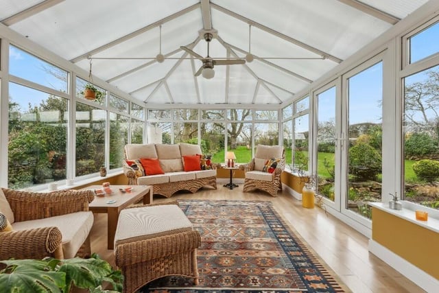 A large conservatory, with doors leading outside, has great views across the garden.
