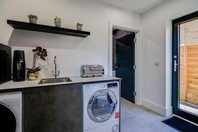 This room features storage cupboards and a built in laundry shoot from the bathroom above. As well as plumbing and drainage for a washing machine with space under the counter.
