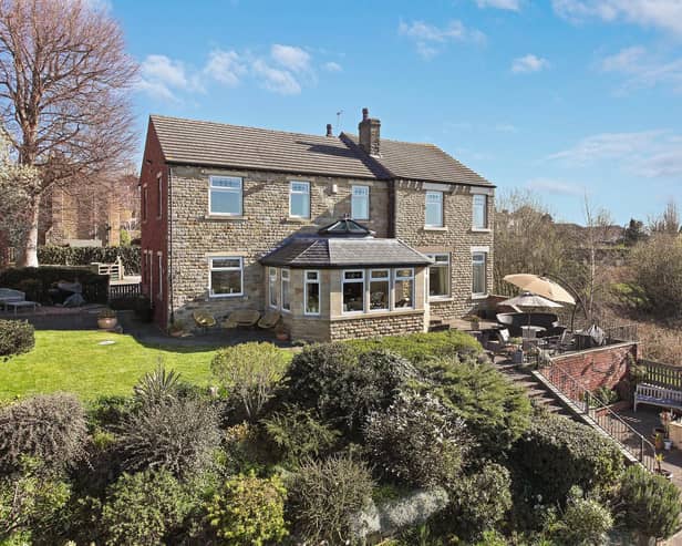 The property stands above tiered gardens and open views.