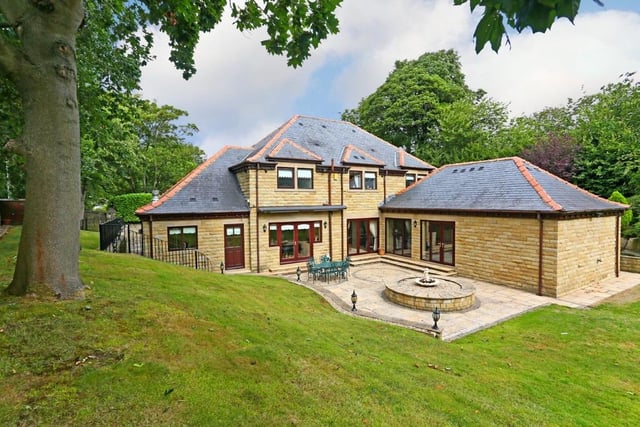 The four-bedroom property stands within lawned gardens with patio areas.