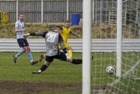 Beverley Town goalkeeper Ben Voase is beaten at his near post by Jack McGahan but the ball hits the post.