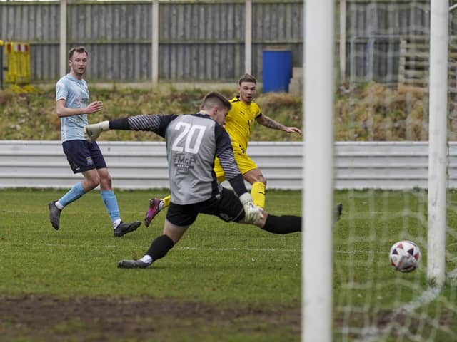 Beverley Town goalkeeper Ben Voase is beaten at his near post by Jack McGahan but the ball hits the post.