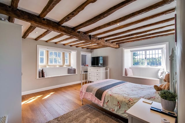One of the double bedrooms, with an oak floor, ceiling beams and window seats.