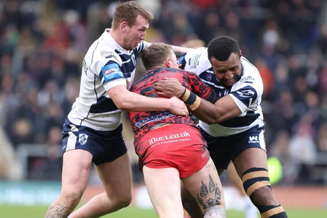 Featherstone Rovers players combine to tackle Leigh's Josh Charnley. Picture: John Victor