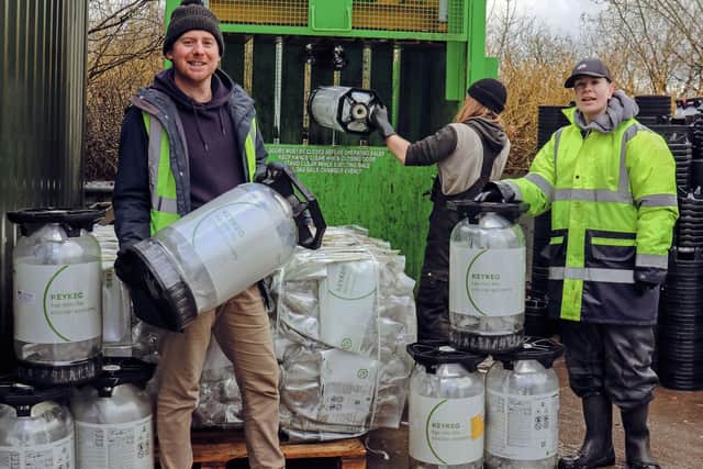 Sam Evans (left) and the WDS Group team crushing and bundling empty KeyKegs.