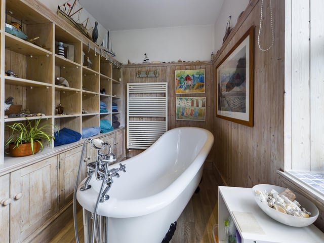 A free standing slipper bath dominates this panelled bathroom.