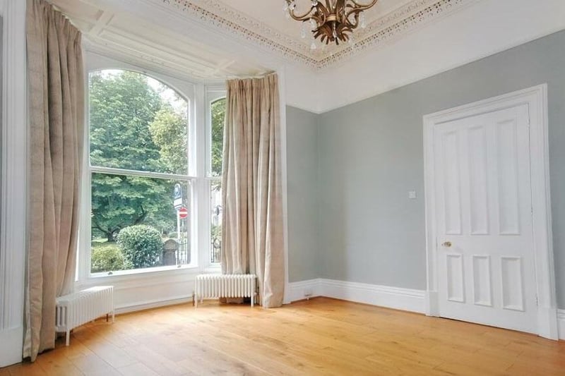 A bay window floods a reception room with natural light.