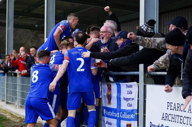 Pontefract Collieries players celebrate their winning goal against Brighouse Town with supporters at the Shed End. Picture: Josh Harper