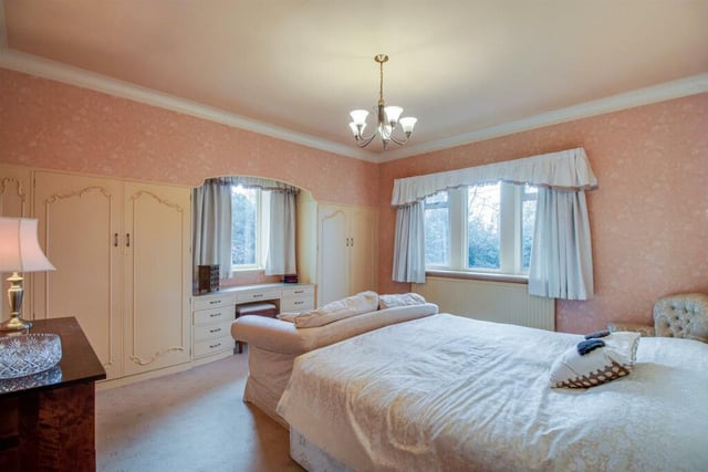 Bedroom two features a window overlooking the gardens to the front, built in wardrobes with matching cupboards and drawers, a vanity wash basin, double central heating radiator and a useful overstair cupboard.