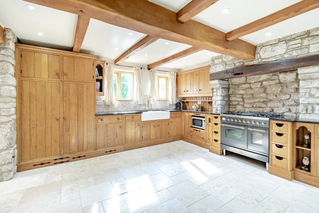 The beamed and fitted kitchen with handmade oak units, granite worktops and a range cooker.