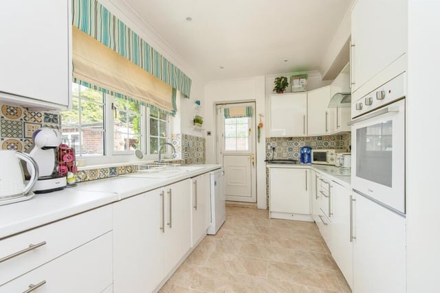 This extensively fitted kitchen features beautiful glossy white cabinets.