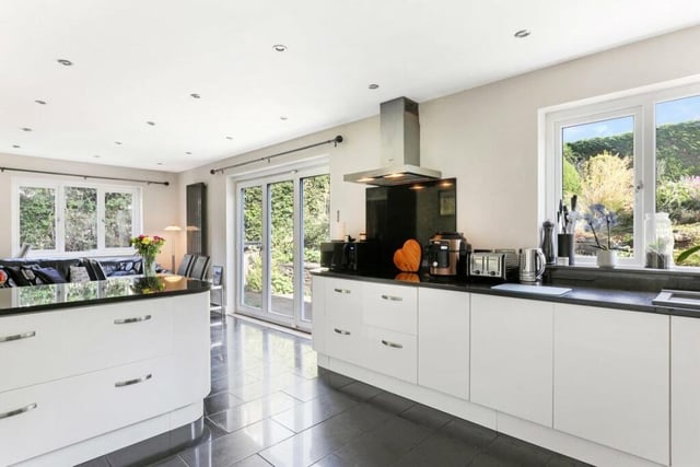 The kitchen is superbly appointed with a range of high gloss fronted wall and base units, contrasting granite worktops with it extending to breakfast bar with bi-folding doors that lead onto the rear garden.