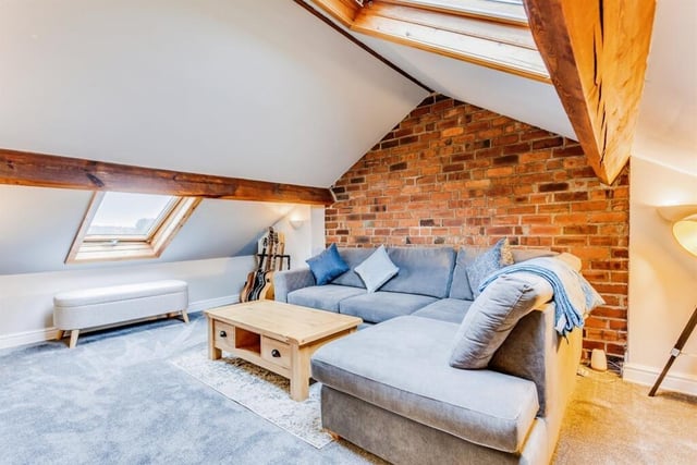 Ceiling beams and an exposed brick wall add character to this second floor room.