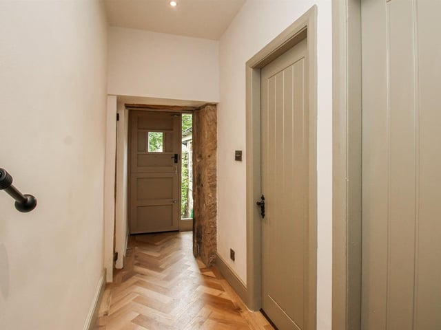 A timber-framed stable entrance door leads into the entrance hall which has exposed stonework, decorative wall panelling and recessed ceiling spotlights.