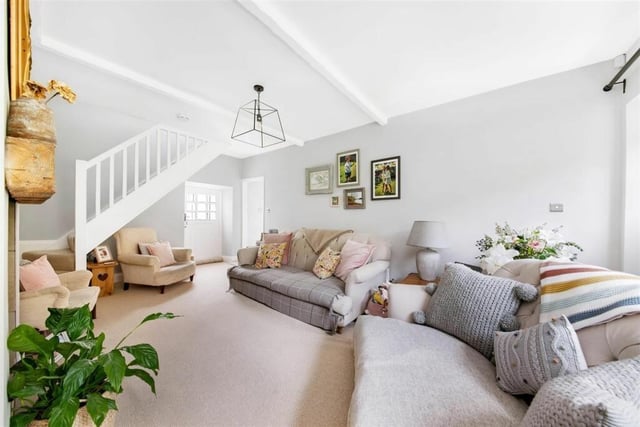 This stunning room features a door out to the front garden, delightful period style window, beams to the ceiling, a beautiful broad fireplace with a raised stone hearth and stone back cloth and a cast wood burning stove with glazed door.