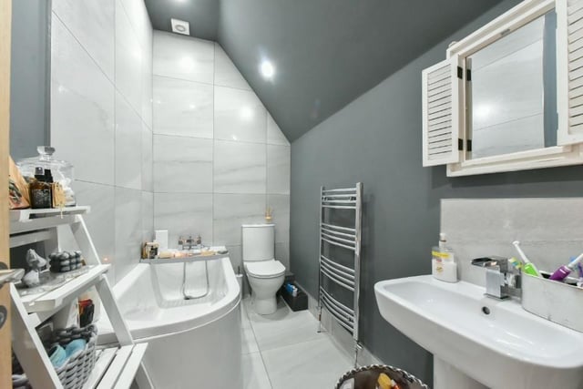 The family bathroom includes a chrome heated towel rail, tiled floor to ceiling over bath and a push button WC.