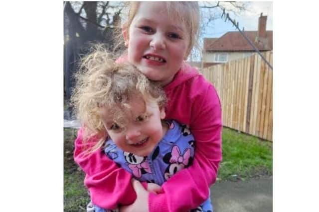 Thea-Mae loves cuddles with her big sister Aya.
