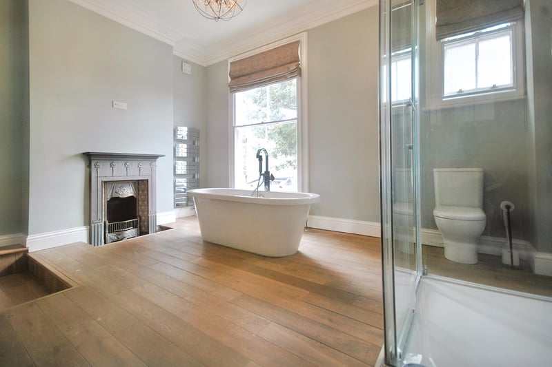 A period fireplace is a feature in this spacious bathroom.