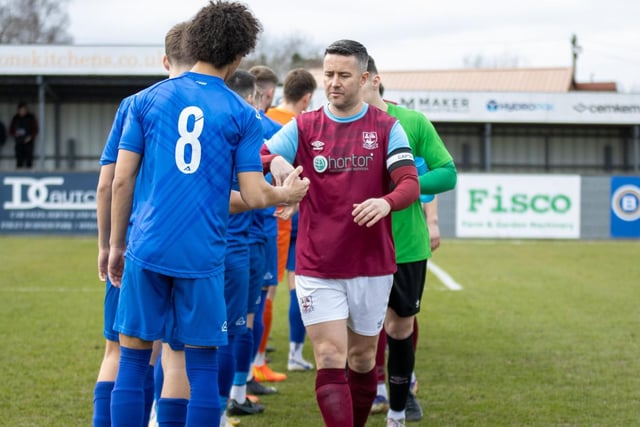 Emley captain James Knowles reaches the end of the line of Hemsworth MW players as the team greet each other ahead of the NCE Premier League game.