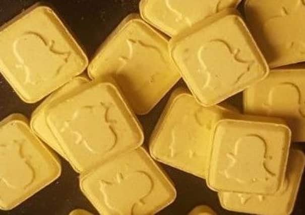 Some examples of the pills are described as small, yellow, brick-shaped tablets bearing the mobile app's logo.
